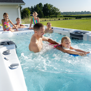 Family enjoying time together in a swim spa.