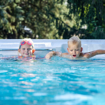 Two kids in the water of a MasterSpas swim spa.
