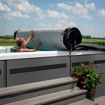 Woman rolling back the cover on her swim spa.